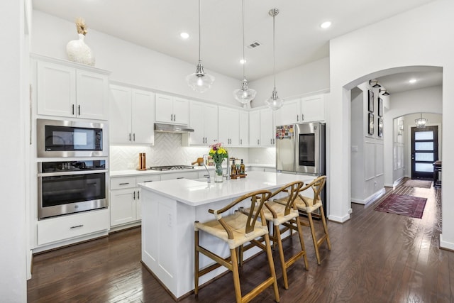 kitchen featuring white cabinetry, a center island with sink, and stainless steel appliances