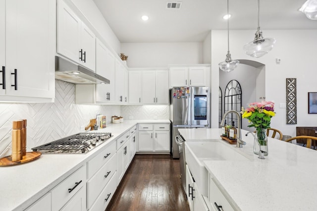 kitchen with decorative light fixtures, white cabinets, tasteful backsplash, and stainless steel appliances