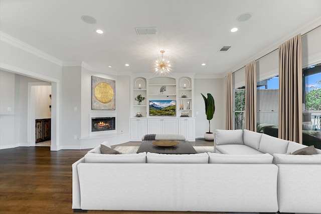 living room with dark wood-type flooring, built in shelves, crown molding, and an inviting chandelier