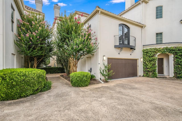 view of front of property featuring a garage and a balcony