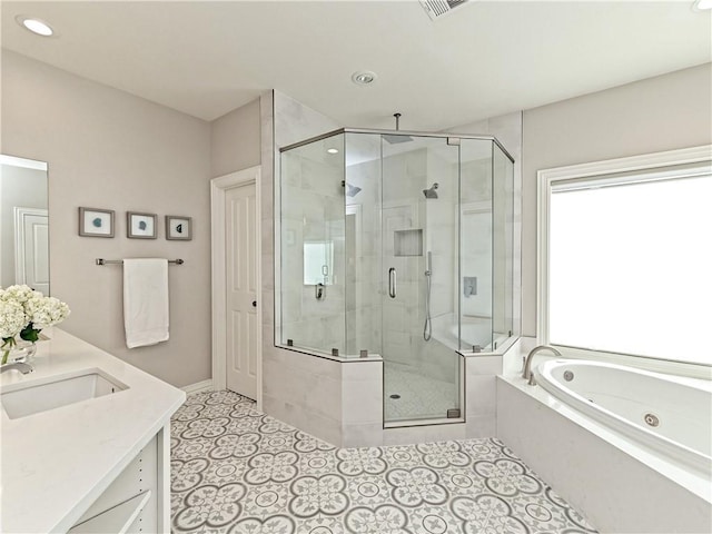 bathroom with a tub with jets, a stall shower, vanity, and tile patterned flooring