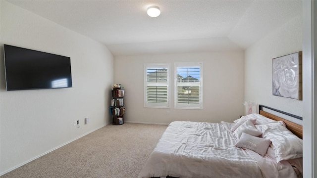 bedroom with lofted ceiling and light carpet