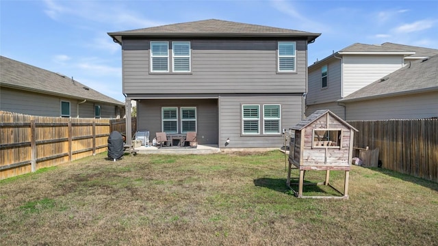 back of property featuring a yard, an outdoor structure, and a patio