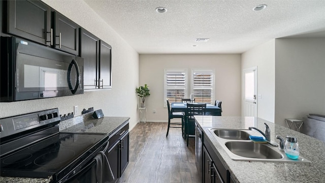 kitchen with sink, a textured ceiling, dark hardwood / wood-style flooring, and black appliances