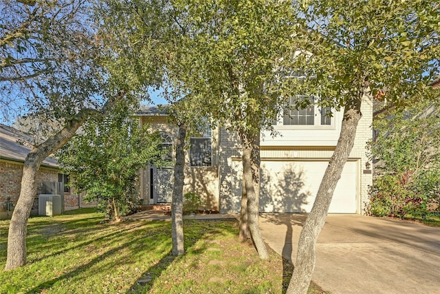 obstructed view of property featuring a garage and a front lawn