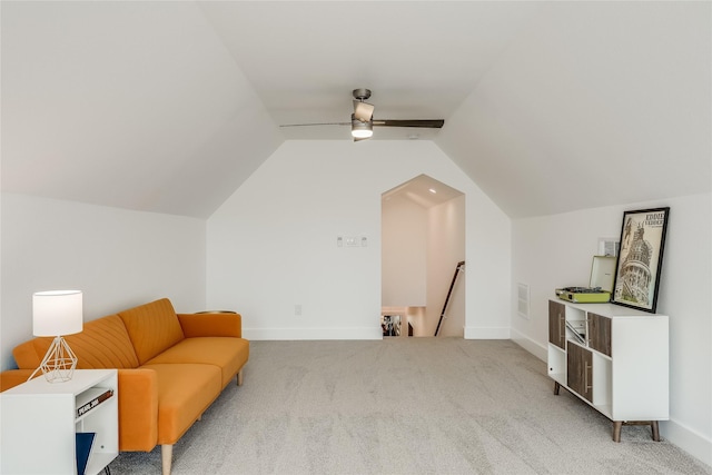 living area featuring light colored carpet, vaulted ceiling, and ceiling fan