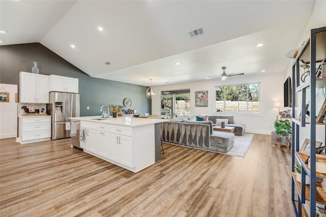 kitchen with stainless steel appliances, a kitchen island with sink, and light hardwood / wood-style floors