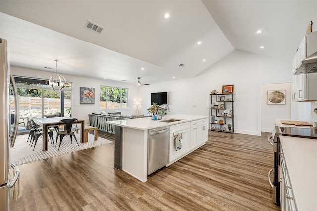 kitchen featuring pendant lighting, appliances with stainless steel finishes, white cabinetry, sink, and a kitchen island with sink