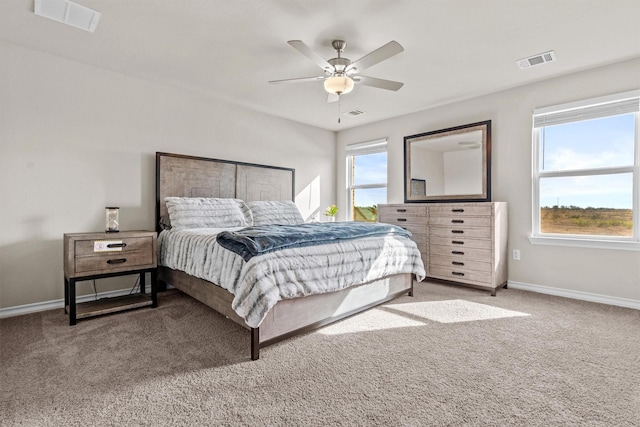 carpeted bedroom with ceiling fan and multiple windows