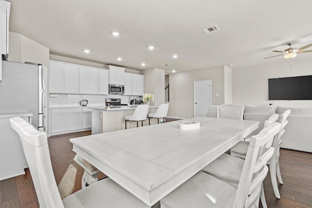 dining space with ceiling fan and dark hardwood / wood-style floors