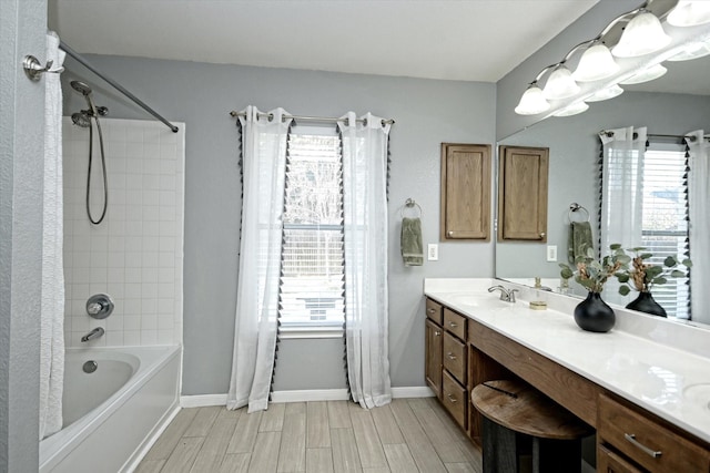 bathroom featuring plenty of natural light, vanity, and tiled shower / bath