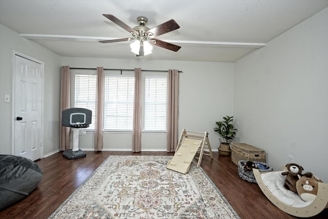 living area with ceiling fan, dark hardwood / wood-style flooring, and beam ceiling