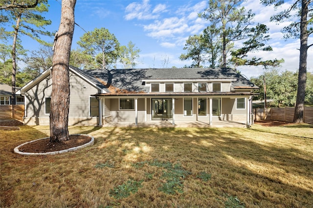 back of property with a lawn and a patio