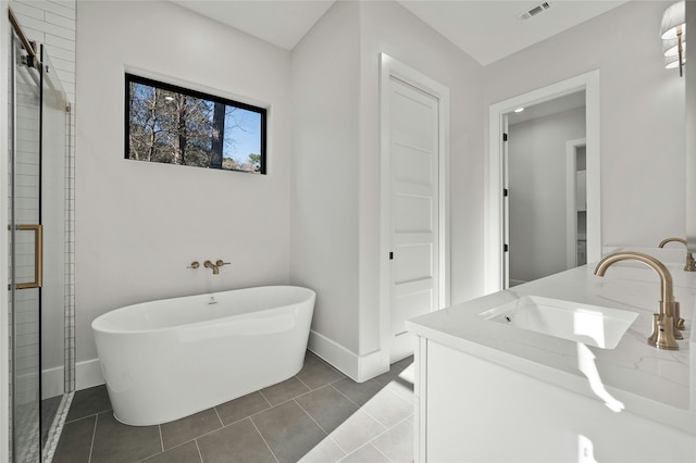 bathroom with a tub to relax in, tile patterned floors, and vanity