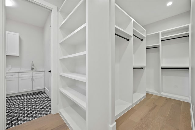 spacious closet featuring sink and light wood-type flooring