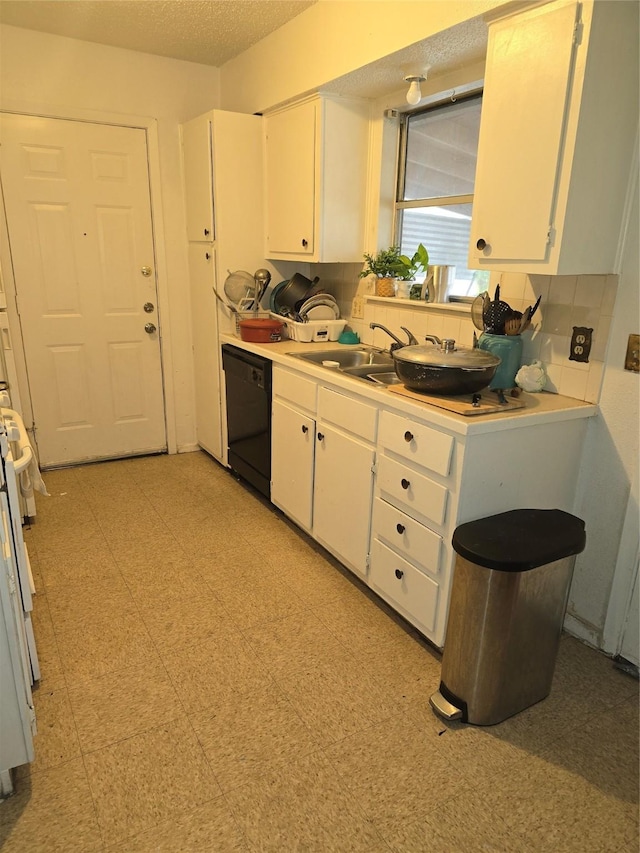 kitchen with sink, dishwasher, white cabinetry, and a textured ceiling