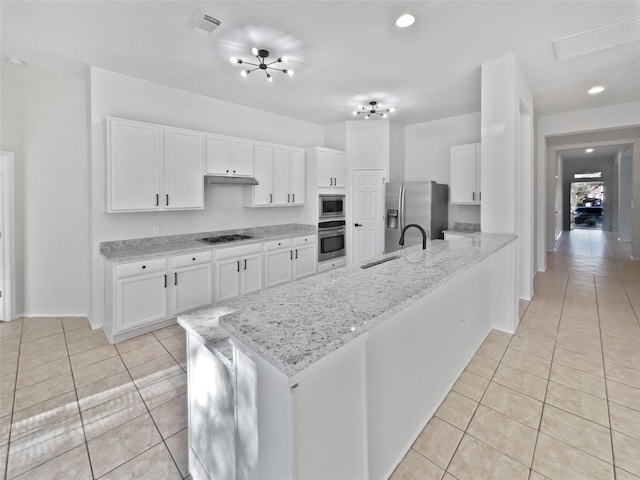 kitchen with light stone countertops, appliances with stainless steel finishes, white cabinetry, sink, and light tile patterned floors