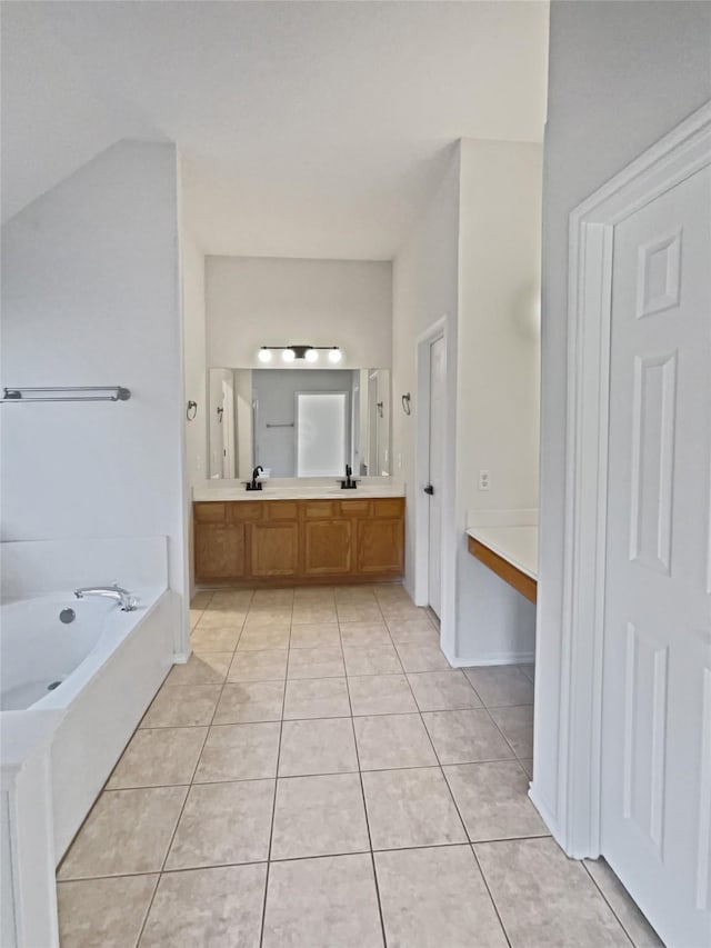 bathroom featuring a bathtub, vanity, and tile patterned flooring