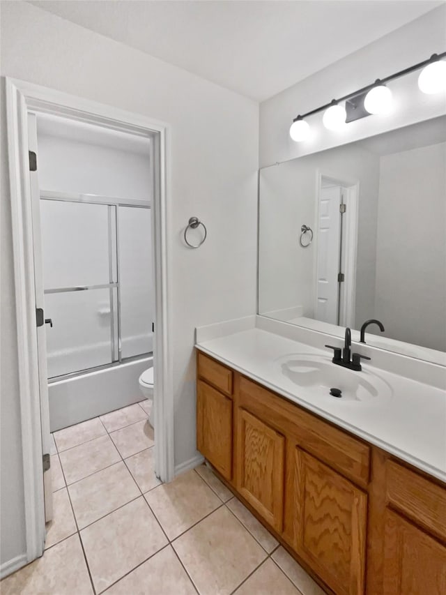 full bathroom featuring combined bath / shower with glass door, toilet, tile patterned floors, and vanity