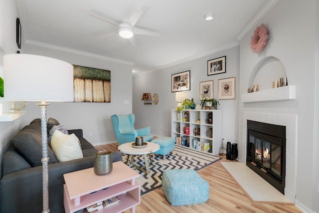 living room with light hardwood / wood-style floors, ceiling fan, and ornamental molding