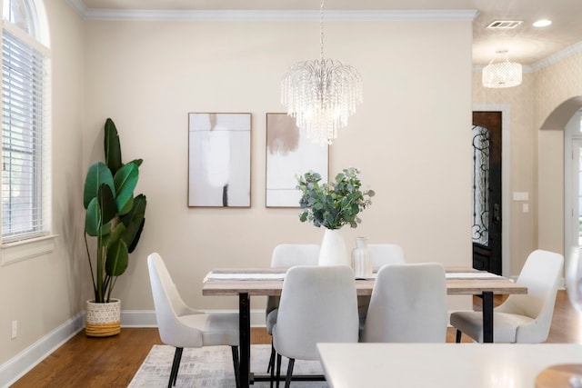 2407 Enfield Rd Unit A, Austin, TX 78703 - dining area with arched walkways, wood finished floors, a chandelier, ornamental molding, and plenty of natural light