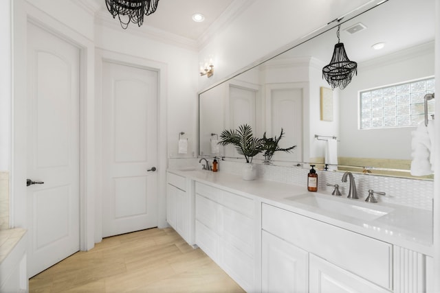 bathroom with vanity, crown molding, and a notable chandelier