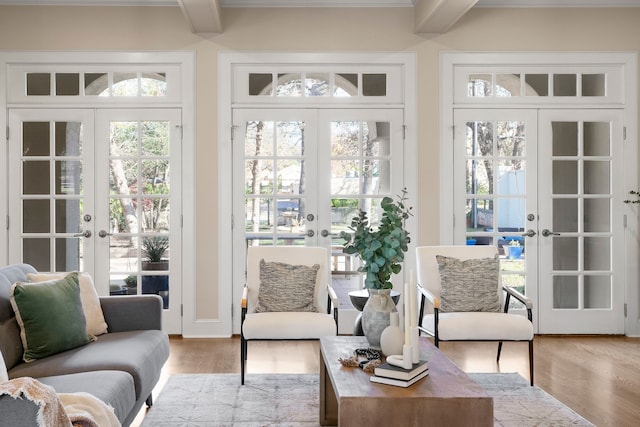 sunroom featuring beam ceiling and french doors