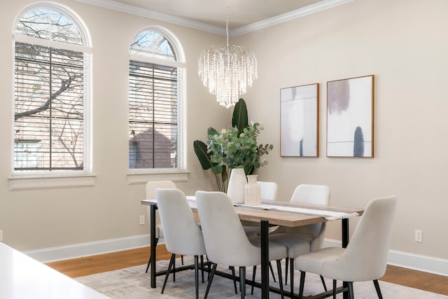 dining room with a chandelier, crown molding, and light hardwood / wood-style floors