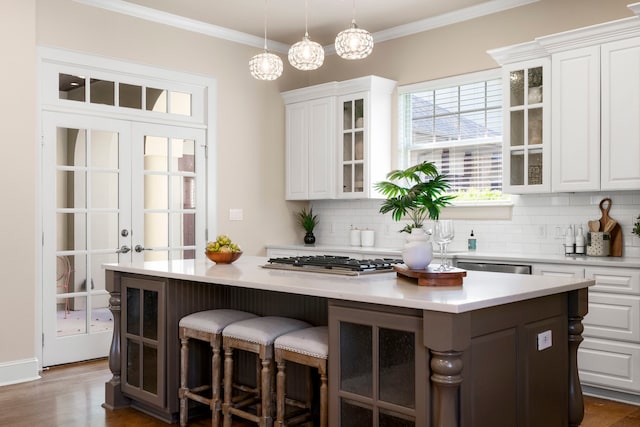 bar with pendant lighting, white cabinetry, dark hardwood / wood-style flooring, stainless steel appliances, and tasteful backsplash