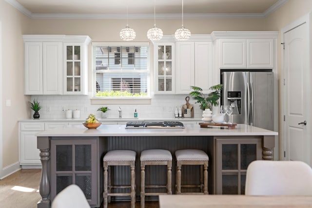 kitchen featuring white cabinets, a center island, decorative backsplash, and appliances with stainless steel finishes