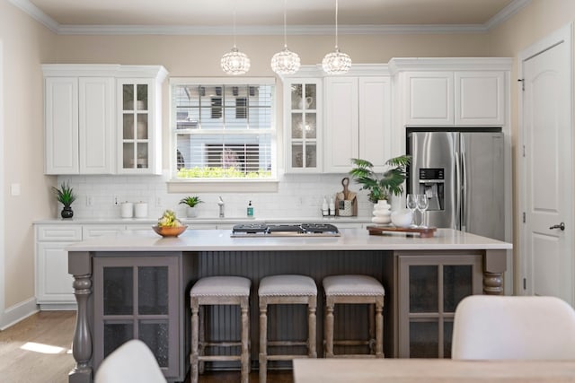 2407 Enfield Rd Unit A, Austin, TX 78703 - kitchen featuring a kitchen breakfast bar, white cabinets, appliances with stainless steel finishes, and ornamental molding