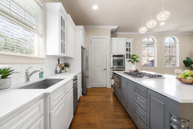 kitchen featuring white cabinets, decorative light fixtures, stainless steel appliances, sink, and gray cabinetry