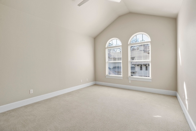 carpeted empty room featuring vaulted ceiling