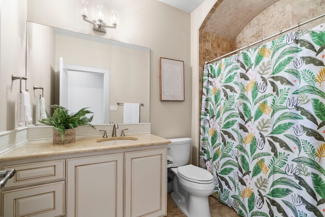 bathroom featuring toilet, vanity, and a shower with shower curtain