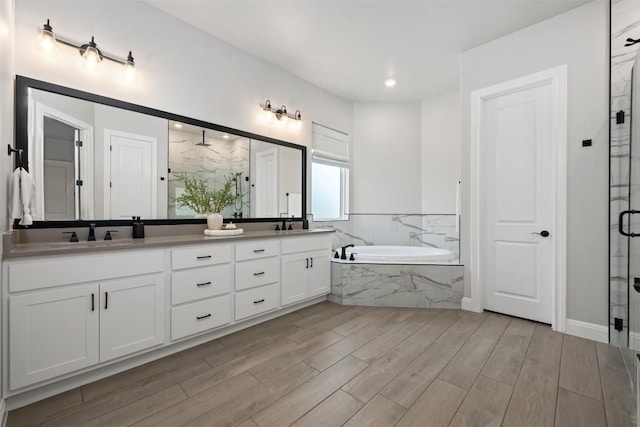210 Miranda Way, Georgetown, TX 78633 - bathroom featuring a marble finish shower, a bath, double vanity, and wood finished floors