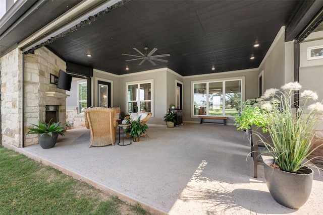 view of patio / terrace featuring ceiling fan and an outdoor stone fireplace