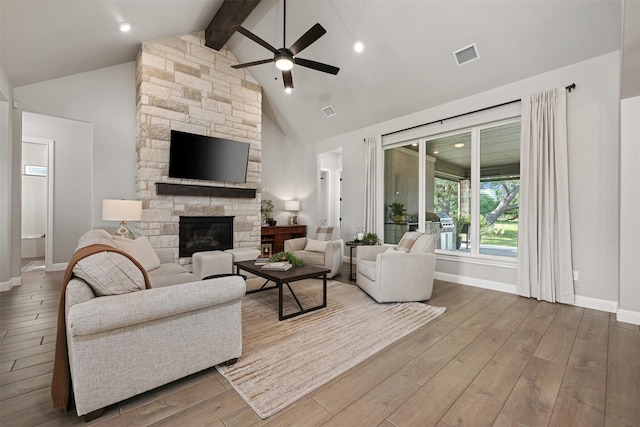 living room with ceiling fan, beam ceiling, a fireplace, hardwood / wood-style floors, and high vaulted ceiling