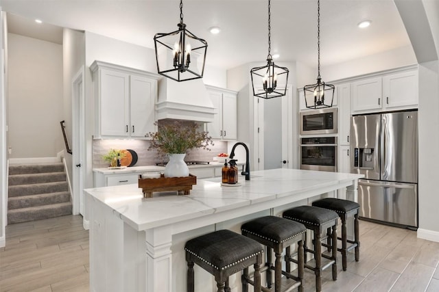 210 Miranda Way, Georgetown, TX 78633 - kitchen with appliances with stainless steel finishes, a chandelier, tasteful backsplash, decorative light fixtures, and a kitchen island with sink