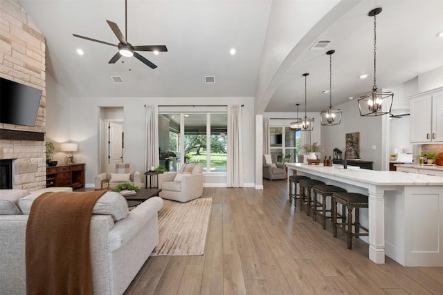 210 Miranda Way, Georgetown, TX 78633 - living area with a ceiling fan, a fireplace, light wood-style flooring, a chandelier, and high vaulted ceiling