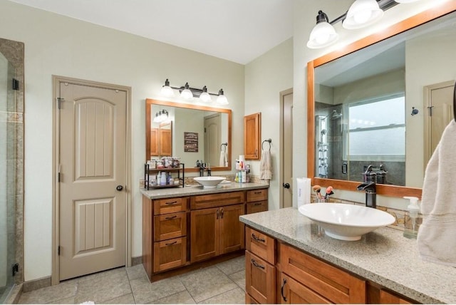 bathroom with a stall shower, two vanities, a sink, and tile patterned floors