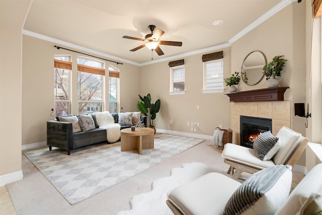 carpeted living room featuring ceiling fan, ornamental molding, and a tiled fireplace