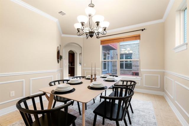 tiled dining room featuring crown molding and a chandelier