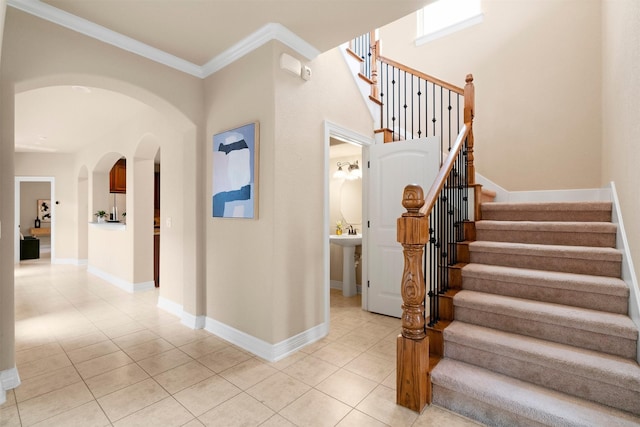 staircase featuring tile patterned floors and ornamental molding