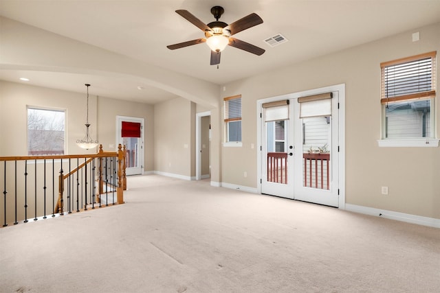 empty room featuring light colored carpet, french doors, and ceiling fan