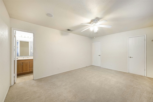 unfurnished room featuring light carpet, sink, and ceiling fan