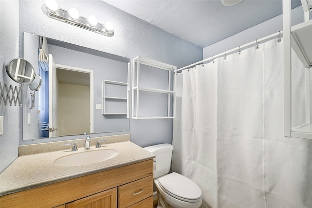 bathroom featuring a textured ceiling, curtained shower, toilet, and vanity