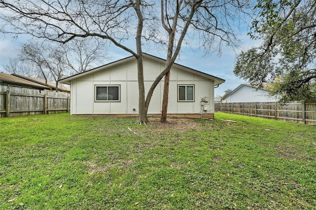 rear view of property featuring a lawn