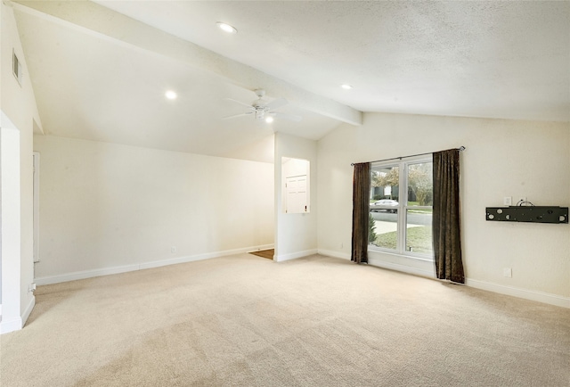 carpeted spare room with ceiling fan, a textured ceiling, and lofted ceiling with beams