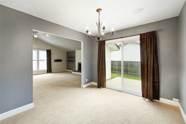 empty room with vaulted ceiling, light colored carpet, and plenty of natural light