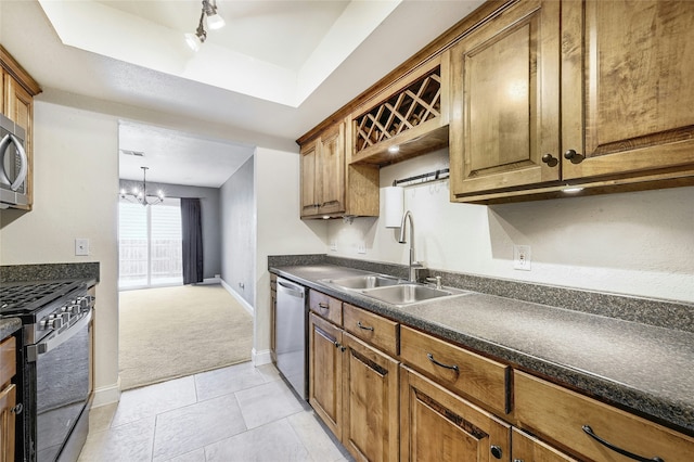 kitchen featuring sink, light colored carpet, a notable chandelier, and stainless steel appliances